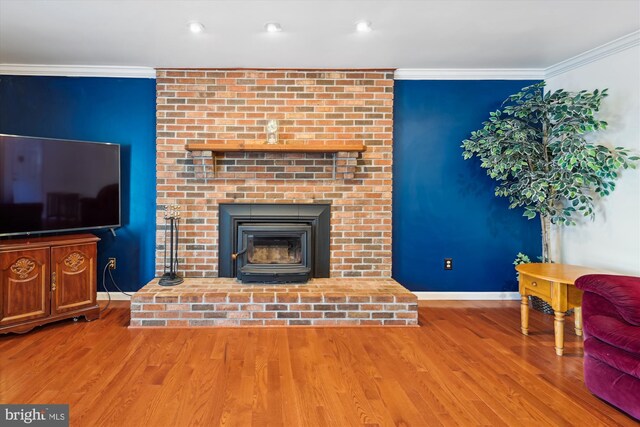 living room featuring baseboards, wood finished floors, and ornamental molding