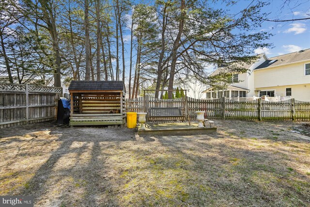 view of yard with an outdoor structure, a fenced backyard, and a shed