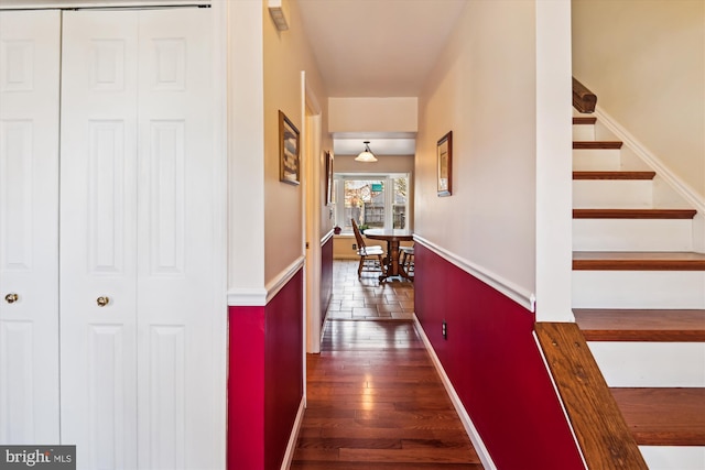 hall featuring stairs, baseboards, and dark wood-style flooring