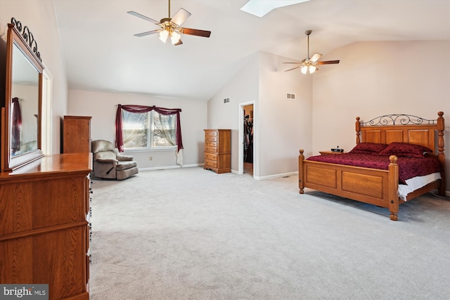 bedroom with a skylight, a spacious closet, carpet, and baseboards