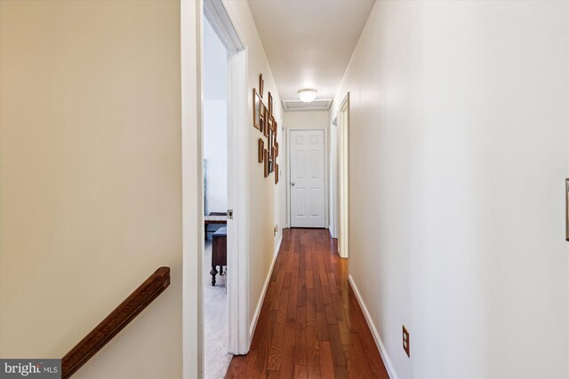 hall featuring attic access, an upstairs landing, baseboards, and dark wood-type flooring