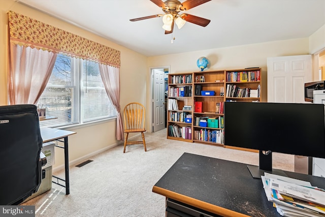 carpeted office featuring a ceiling fan, visible vents, and baseboards