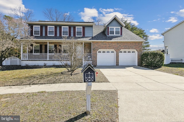 view of front facade with brick siding, a front lawn, covered porch, a garage, and driveway