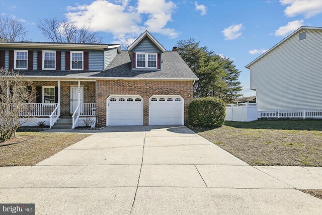 traditional-style house with brick siding, a porch, driveway, and a garage