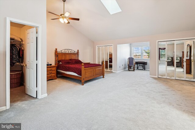 bedroom featuring a skylight, carpet, baseboards, and high vaulted ceiling