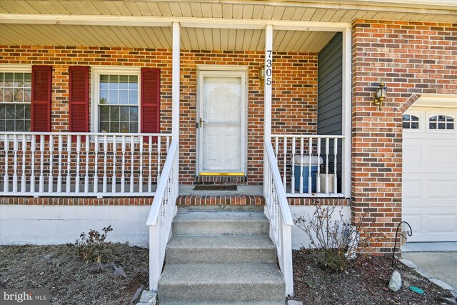 entrance to property featuring brick siding and covered porch