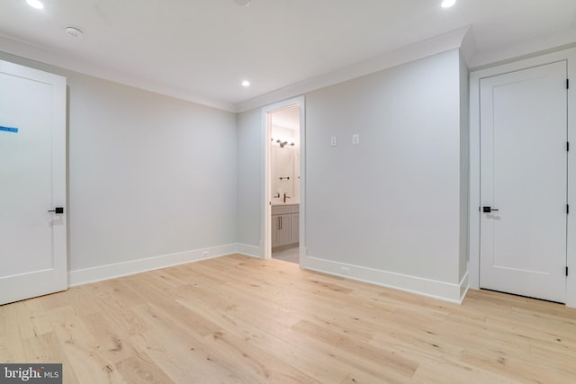 spare room featuring light wood-style flooring, baseboards, crown molding, and recessed lighting