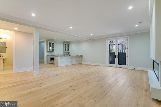 unfurnished living room with light wood-style flooring, baseboards, french doors, and recessed lighting