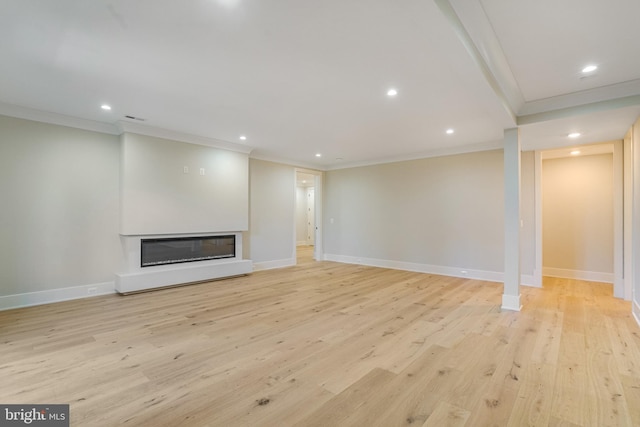 unfurnished living room featuring crown molding, recessed lighting, light wood-style floors, a glass covered fireplace, and baseboards