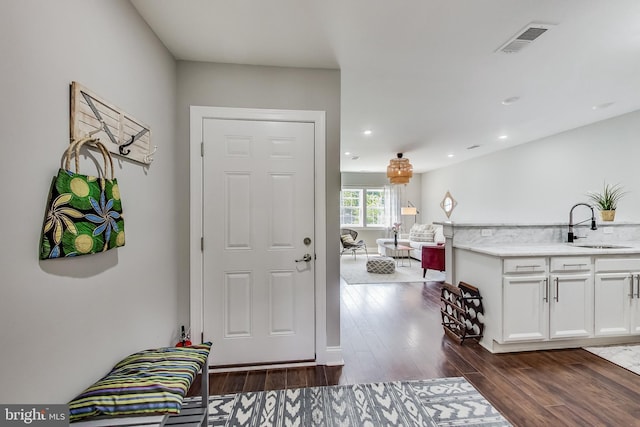 foyer entrance with visible vents, dark wood-style flooring, and recessed lighting