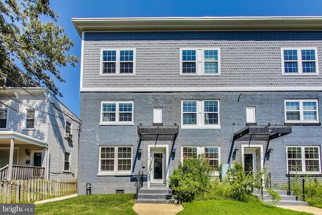 multi unit property with brick siding, crawl space, fence, a pergola, and a front yard