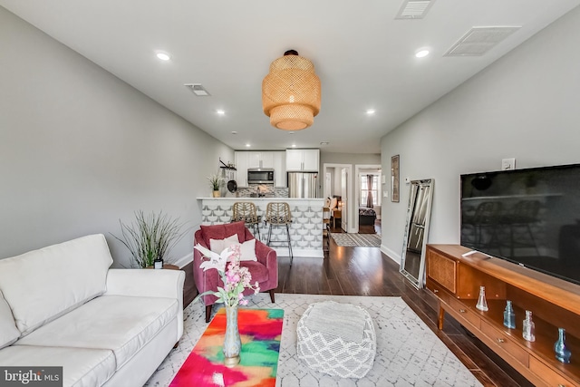 living area featuring dark wood-type flooring, recessed lighting, and visible vents