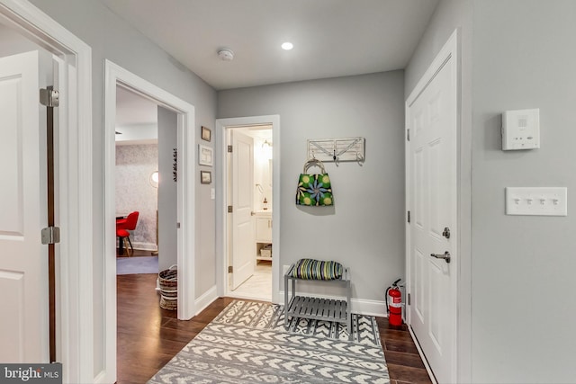 hallway featuring baseboards, dark wood-type flooring, and recessed lighting