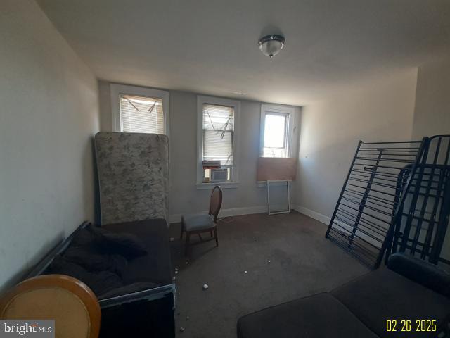 living area featuring baseboards and an upstairs landing