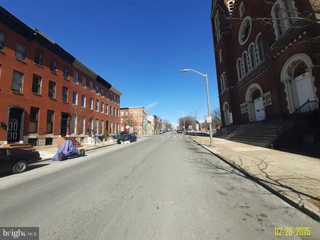 view of road featuring curbs, street lighting, and sidewalks