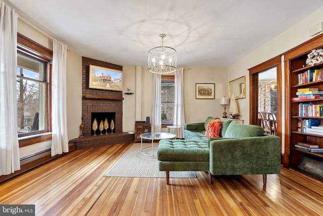 living area featuring a healthy amount of sunlight, light wood-type flooring, and a fireplace