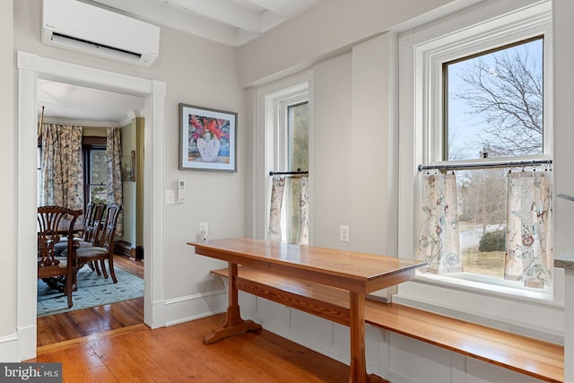 dining space with light wood-type flooring, baseboards, a wealth of natural light, and a wall mounted AC