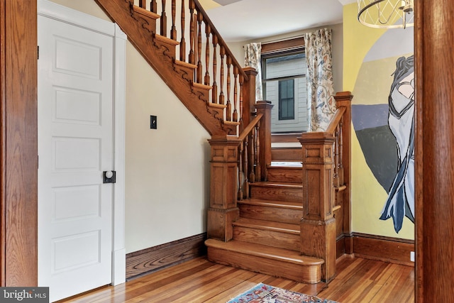 stairway featuring wood-type flooring and baseboards