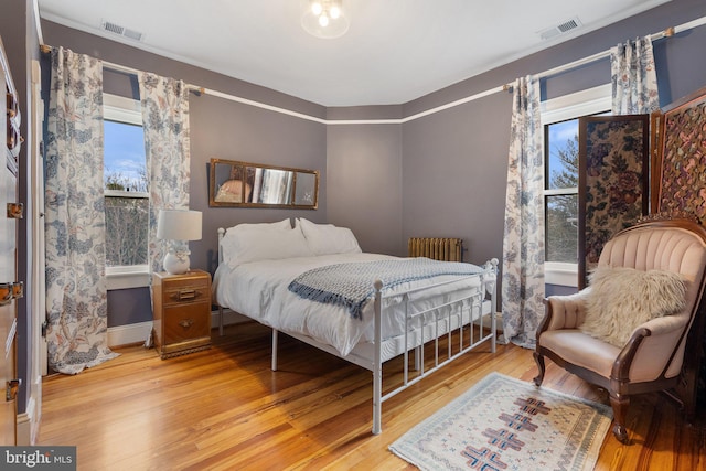 bedroom with visible vents and wood finished floors