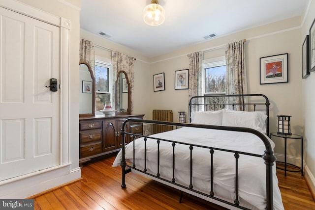 bedroom featuring baseboards, visible vents, and hardwood / wood-style floors