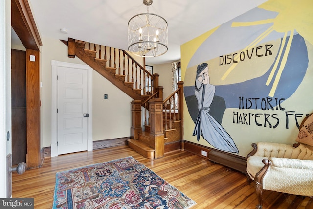 entryway with a chandelier, stairway, baseboards, and wood finished floors