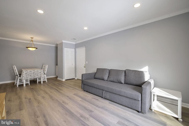 living room featuring light wood-style floors, recessed lighting, crown molding, and baseboards