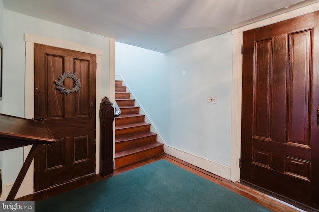 entryway featuring stairway, baseboards, and wood finished floors