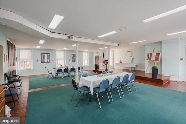 dining space featuring wood finished floors, visible vents, and baseboards