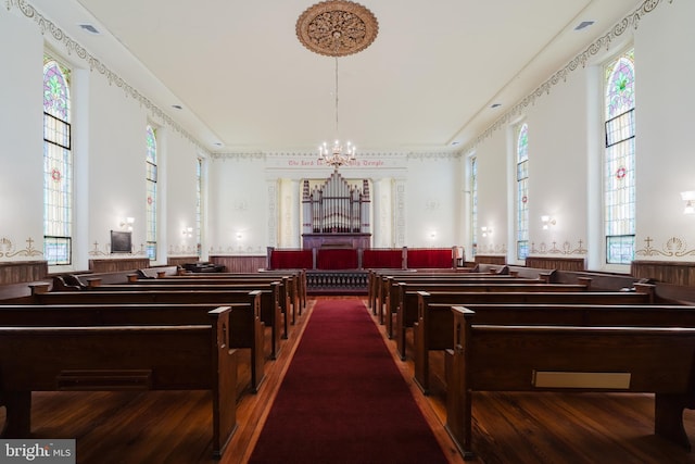 interior space featuring wood finished floors, wainscoting, wallpapered walls, and an inviting chandelier