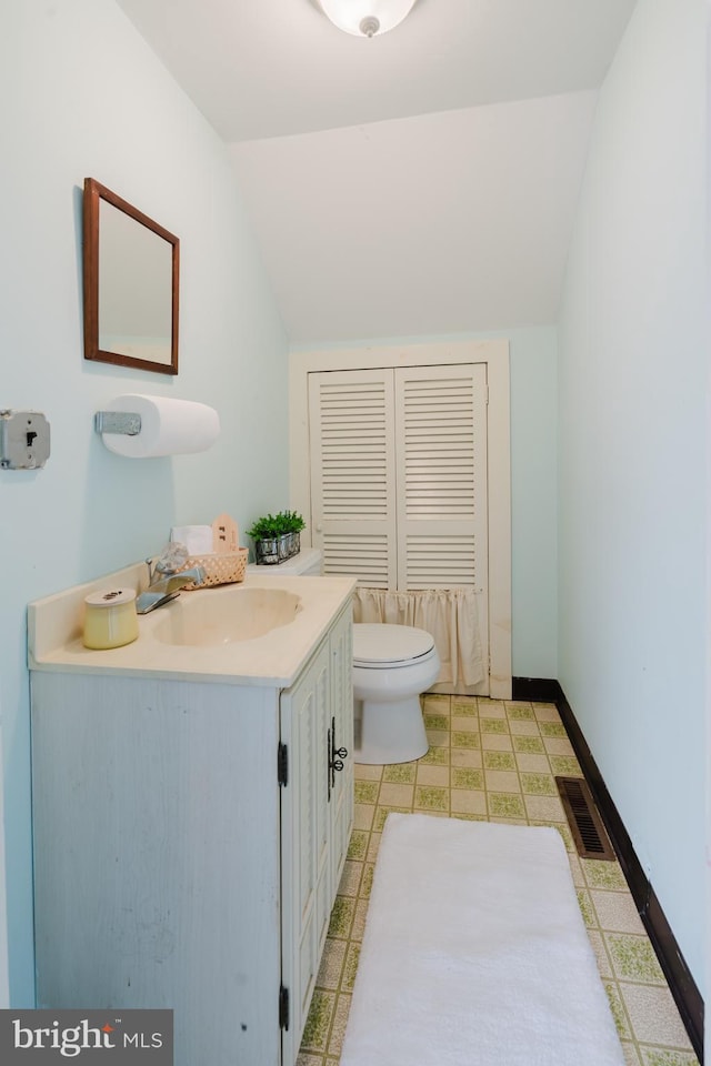 half bath featuring lofted ceiling, visible vents, toilet, baseboards, and tile patterned floors