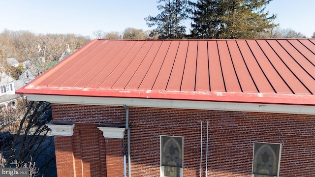 exterior details featuring metal roof, brick siding, and a standing seam roof