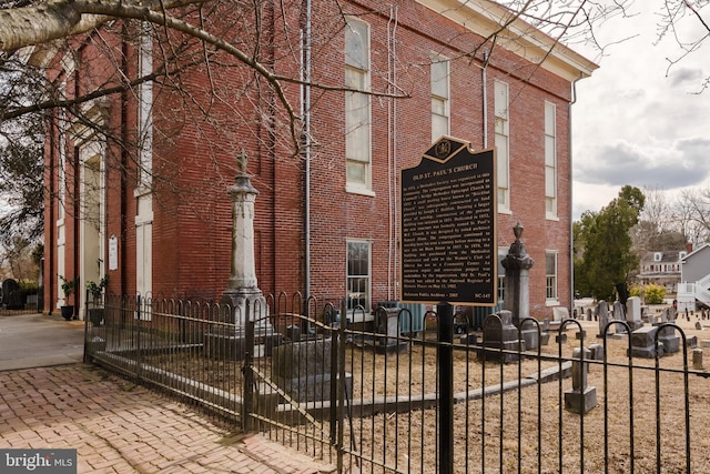 view of home's exterior with brick siding and a fenced front yard