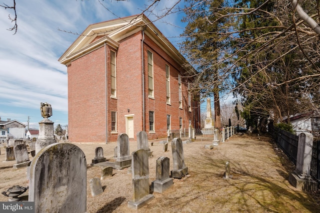 view of home's exterior with brick siding and fence