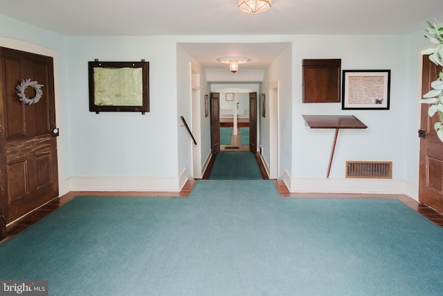 foyer entrance featuring carpet, visible vents, and baseboards