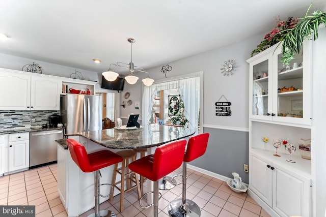 kitchen featuring white cabinets, glass insert cabinets, and stainless steel appliances