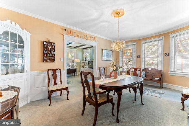 dining room with light carpet, crown molding, and a notable chandelier