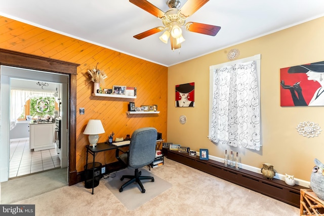 home office with light carpet, light tile patterned floors, baseboards, ceiling fan, and crown molding