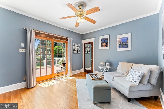 living room with ornamental molding, wood finished floors, and baseboards