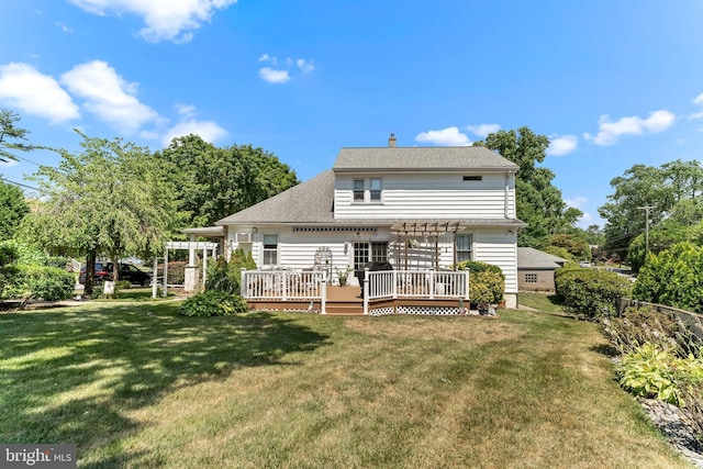 back of property with a deck, a shingled roof, a lawn, and a pergola