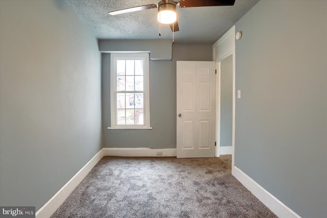unfurnished bedroom with a textured ceiling, carpet flooring, a ceiling fan, and baseboards