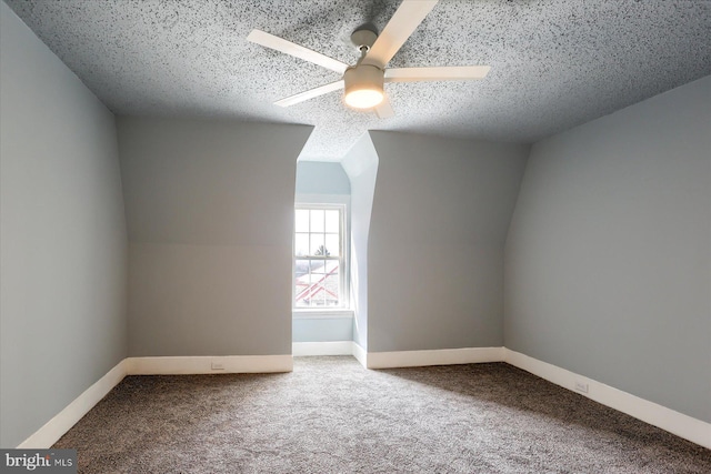 additional living space with baseboards, a ceiling fan, lofted ceiling, a textured ceiling, and carpet flooring