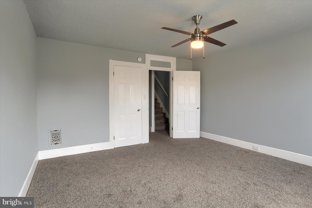 unfurnished bedroom with carpet, baseboards, and a textured ceiling