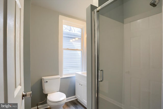 full bathroom featuring toilet, a stall shower, vanity, wood finished floors, and baseboards