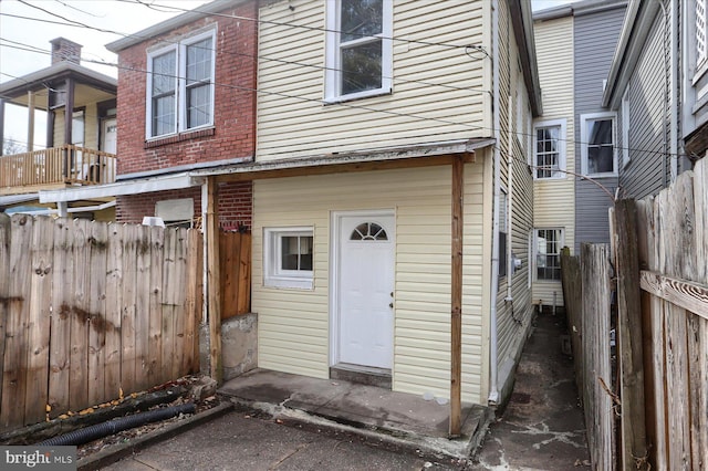 rear view of house with fence and brick siding