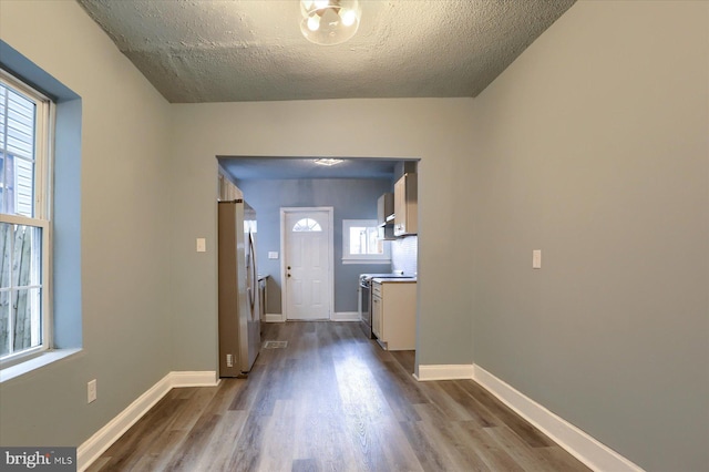 entrance foyer featuring dark wood-type flooring, a textured ceiling, and baseboards