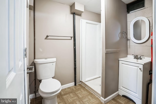 bathroom with vanity, toilet, and baseboards