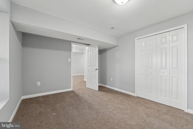 unfurnished bedroom featuring carpet floors, a closet, visible vents, and baseboards