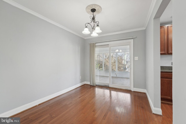 unfurnished dining area featuring ornamental molding, wood-type flooring, and baseboards