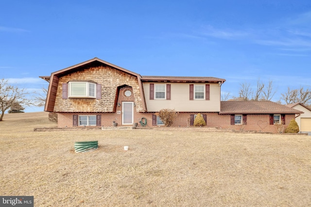 bi-level home with brick siding and a front lawn