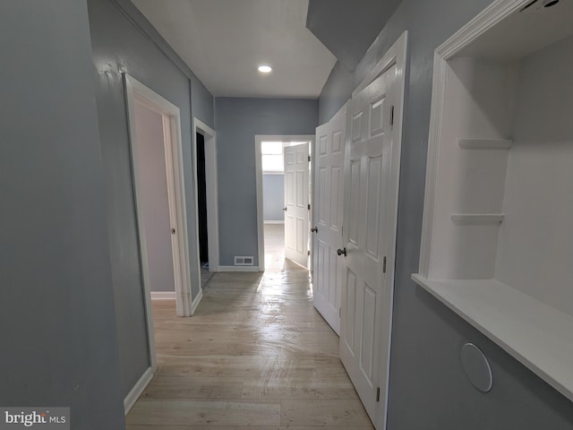 hallway with light wood-style floors, recessed lighting, visible vents, and baseboards